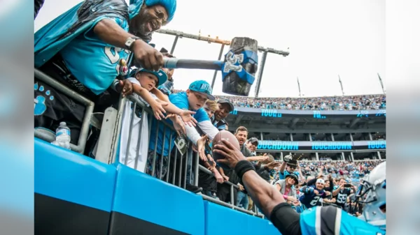 Cam Newton giving the TD ball to a young fan (2017).webp